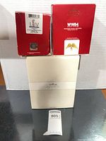 Two red Keepsake ornament boxes stacked on cream Hallmark box