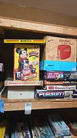 All boxed items stacked on shelf showing titles and brands