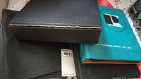 Four binders including two black stock books and teal binder
