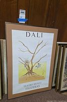 Full framed Dalí exhibition poster leaning against wall