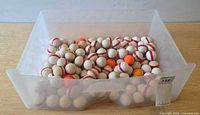 Clear plastic drawer filled with golf balls, exterior view