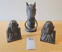 Group view of two Franklin bookends and horse head hitching post