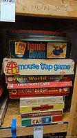 Stack of nine boxed board games showing titles and wear