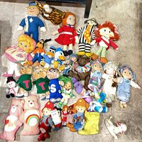 Overall view of entire assortment of plush and rag dolls on floor