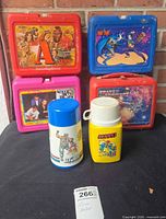 Front view of four lunchboxes and two standalone thermoses