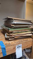 Stack of assorted vintage paper items on workbench