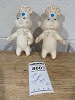 Both Pillsbury Doughboy figures standing on table