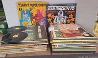 Front view of stacked LP albums with two 45s on top, visible titles Today’s Super Greats and Star Trackin’ ’76