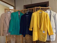 Five blazers hanging showing full fronts and colors