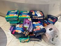 Overview of various feminine hygiene products including Always Ultra Thin pads, Poise liners, and other Always pad packs, mostly sealed.