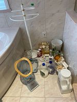 Photo of full set including towel rack, soap dispensers, waste basket, and bath accessories on floor near bathtub