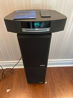 Full view of Bose Wave system stacked on speakers with remote and manual on top