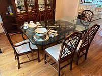 Overall view of glass-top table with six chairs arranged around it