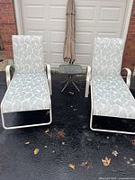 Two loungers side by side with side table and umbrella in background