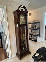 Three-quarter front view of full clock showing bonnet, body and base.