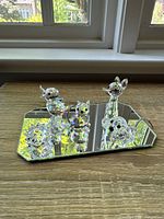 Overall view of all six Swarovski crystal animal figurines displayed on a mirrored base showing their relative sizes and shapes.