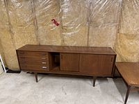 Front view of entire teak sideboard showing four drawers on left, open shelf in center, sliding doors on right