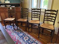 Front view of four chairs side by side on hardwood floor showing overall condition and matching design