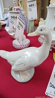 Photo of the white porcelain duck figurine from a side angle showing detailed wings and head position.