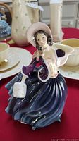 Front side view of the Royal Doulton porcelain figurine showing detailed facial features, bonnet, and basket.