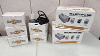 Six PowerSun power supply units shown, five in original white boxes and one unboxed with power cord coiled on top.