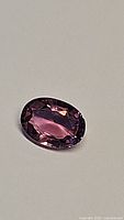 Close-up image of oval cut pink tourmaline gemstone showing facets and clarity