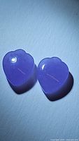 Pair of polished lavender jade fancy spade cabochon gemstones showing smooth surface and glossy finish under lighting