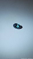 Photo of the natural oval cut aqua blue green topaz gemstone on white background