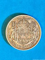 Close-up front side image of the 1941 Canadian 50 cent silver coin showing the detailed coat of arms and inscriptions.