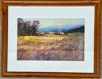 Framed watercolour painting of a country landscape featuring fields, trees, and farm buildings, signed by Art B. Cunanan.