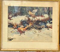 Framed print showing pheasants in a snowy forest landscape with a gold-colored frame and beige matting. Signed in the lower right corner by the artist.