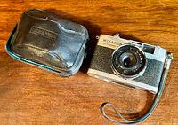 Photo showing Miranda Sensoret camera and black zippered case on wooden surface