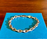 Full view of vintage sterling silver rolo link bracelet displayed on blue box, showing chain style and overall length.