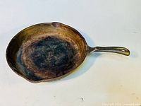 Full view of the cast iron skillet showing the entire skillet with handle and pour spouts.