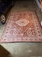 Full view of red oriental patterned area rug laid flat showing overall condition and pattern.