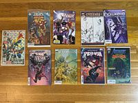 Image of 9 modern Marvel comic books arranged in two rows on wooden floor.