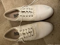 Top view of the pair of white and tan FootJoy women's golf shoes, showing laces and overall shape