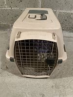 Front view of medium beige Petmate Kennel Cab pet carrier showing metal door and ventilation holes on top