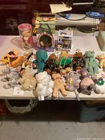 Wide photo showing multiple plush toys and collectibles arranged on a table.