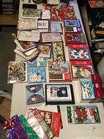 Full view of multiple boxed sets of holiday and birthday greeting cards arranged on a table, showing a variety of colors, sizes, and designs themed around Christmas and birthdays.