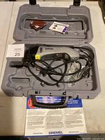 Dremel Multi-Max oscillating tool neatly placed inside its molded gray plastic carrying case with accessories and manual visible.