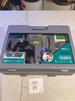 Gray plastic carrying case containing the IQCrew 52-piece microscope set, showing the microscope and accessories inside.