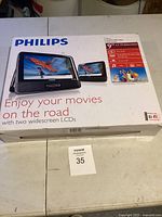 Box of Philips portable DVD player set showing dual widescreen LCD displays and branding.