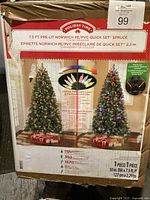 Box with label showing Holiday Time 7.5 ft pre-lit Norwich PE/PVC Quick Set Spruce Christmas Tree with color changing lights and eight-function light controller.