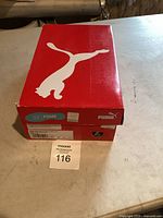 Top view of closed Puma shoe box with white Puma logo on red box.