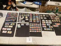 Full view of multiple black album pages with postage stamps arranged in rows