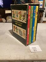 Front view of slipcase and visible four volumes of 'The Wonderful Worlds of Walt Disney' book set on table.