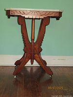 Front view showing carved wood details and marble top