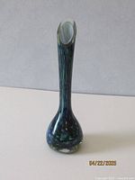 Front view showing gradual color blending in blues and greens with a glossy finish and polished asymmetrical lip