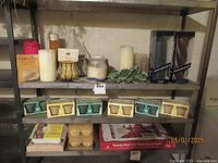 Shelf with assorted candles including pillar candles, boxed scented candles, flameless tea lights, and decorative holders